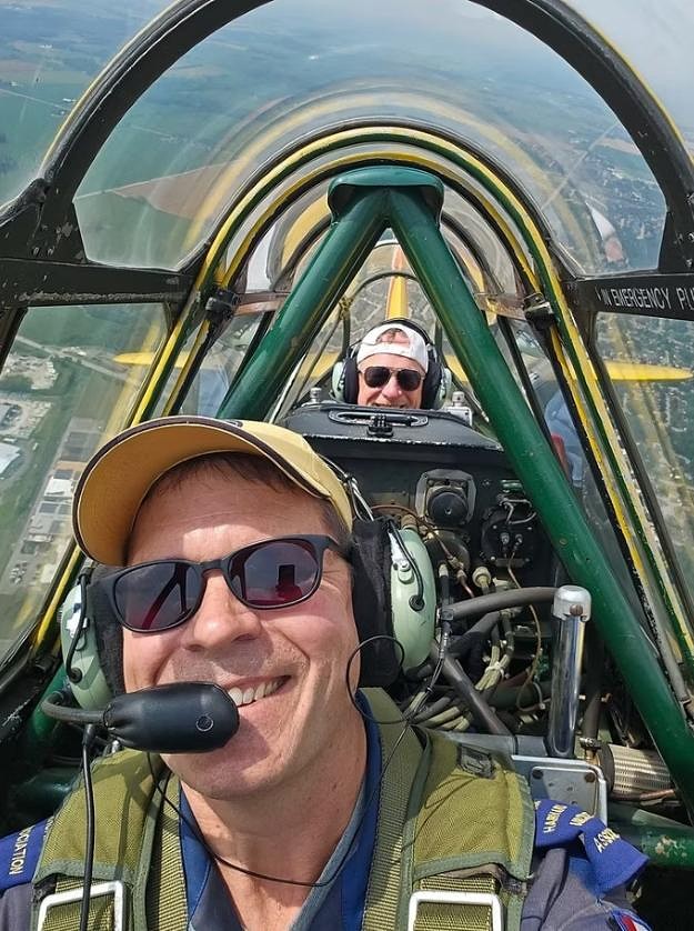 Pilot Sean Voskamp smiles as he takes a Harvard into a climb with editor Jeff Helsdon along as a passenger. This experience is part of the Canadian Harvard Aircraft Association’s fly days, held monthly through the summer. (Sean Voskamp photo).
