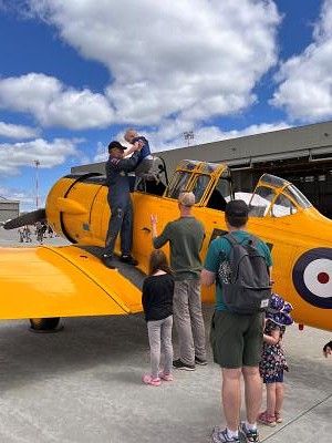 Volunteer with CHAA: Helping child get into cockpit of Harvard