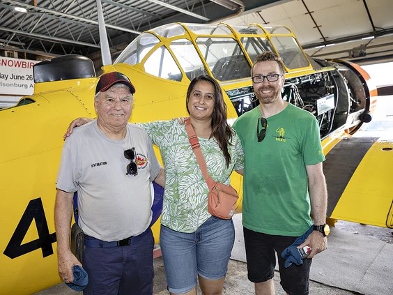 Ted Widish (left) of Tillsonburg stands with his daughter-in-law Nancy and her husband Allen Widish of Milton alongside a Harvard aircraft he is helping restore. Photo by Brian Thompson /The Expositor