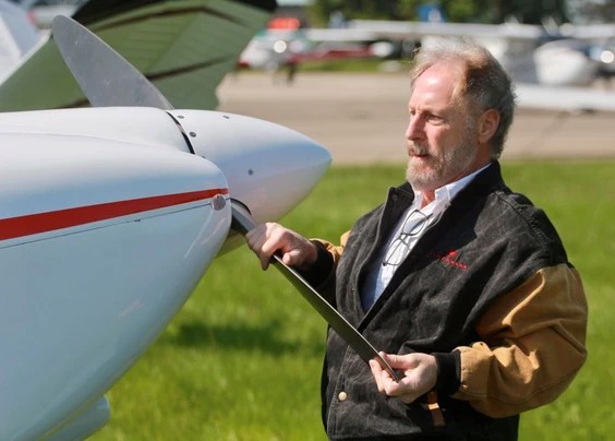 Glen Mair, who co-owns the Van’s RV-6 plane with Hella Comat, moves the aircraft after landing at the Stratford airport. 